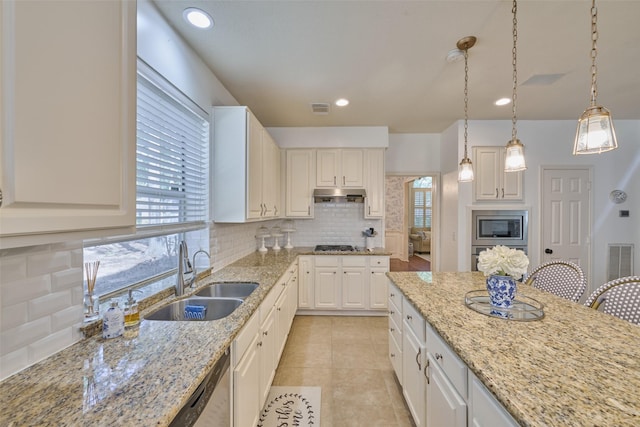 26 E Sterling Pond Cir, The Woodlands, TX 77382 - kitchen featuring a sink, appliances with stainless steel finishes, under cabinet range hood, decorative backsplash, and plenty of natural light