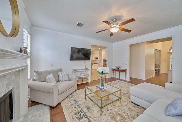 26 E Sterling Pond Cir, The Woodlands, TX 77382 - living room featuring a fireplace, a ceiling fan, ornamental molding, and wood finished floors