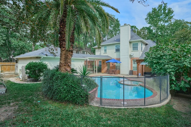 26 E Sterling Pond Cir, The Woodlands, TX 77382 - back of property featuring a pool with connected hot tub, a chimney, and a patio