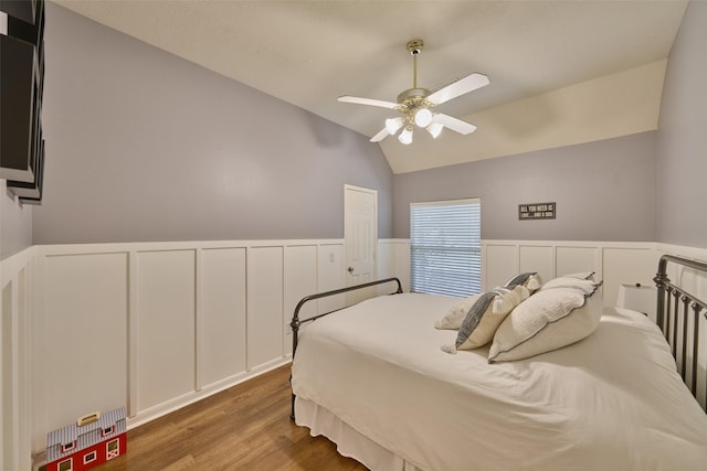 26 E Sterling Pond Cir, The Woodlands, TX 77382 - bedroom with lofted ceiling, a wainscoted wall, wood finished floors, a decorative wall, and ceiling fan