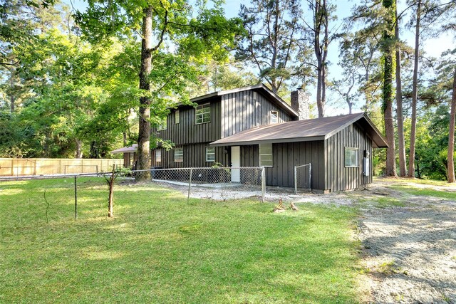 118 Glenview, Livingston, TX 77351 - rear view of house featuring a chimney and board and batten siding
