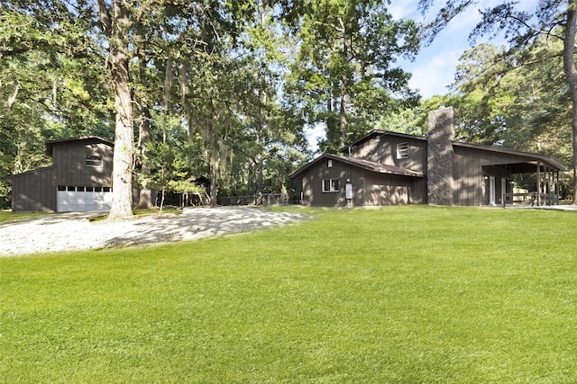 118 Glenview, Livingston, TX 77351 - view of green lawn with a garage, an outbuilding, and gravel driveway