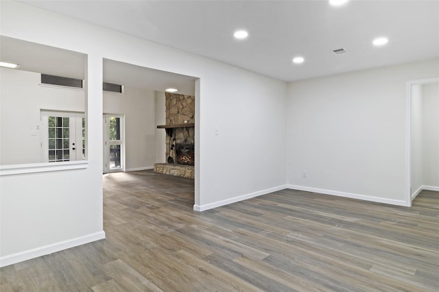 118 Glenview, Livingston, TX 77351 - empty room with wood finished floors, baseboards, recessed lighting, and a stone fireplace