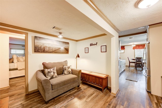 4603 New Orleans St, Houston, TX 77020 - living area featuring crown molding, wood finished floors, a textured ceiling, and baseboards