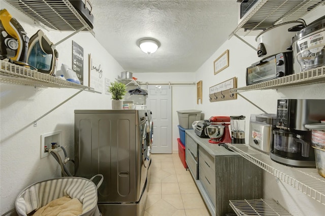 4603 New Orleans St, Houston, TX 77020 - laundry room featuring separate washer and dryer, light tile patterned floors, and a textured ceiling