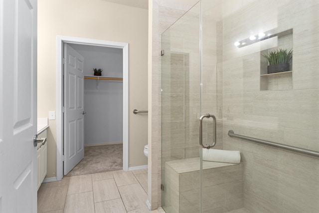 2815 Kings Crossing Dr Unit 102, Houston, TX 77345 - bathroom with a stall shower, toilet, a spacious closet, and baseboards