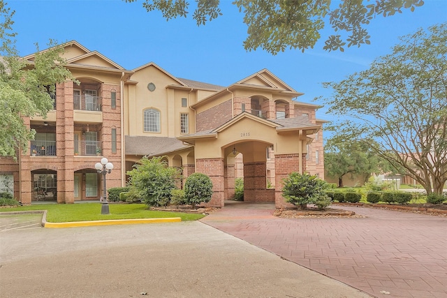 2815 Kings Crossing Dr Unit 102, Houston, TX 77345 - view of front of house with stucco siding, uncovered parking, and a balcony
