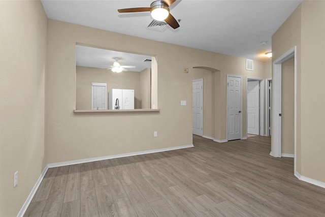 2815 Kings Crossing Dr Unit 102, Houston, TX 77345 - empty room with ceiling fan, wood finished floors, arched walkways, and baseboards