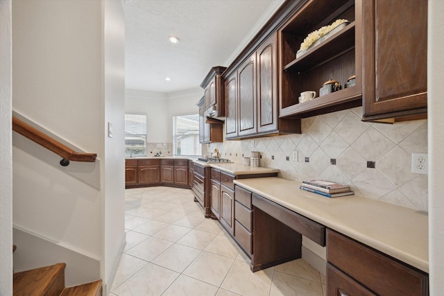 3505 Parkside Dr, Pearland, TX 77584 - kitchen with tasteful backsplash, light tile patterned flooring, light countertops, dark brown cabinets, and crown molding