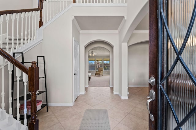 22610 Torrisdale Ln, Tomball, TX 77375 - entryway with crown molding, arched walkways, light tile patterned floors, stairs, and a ceiling fan