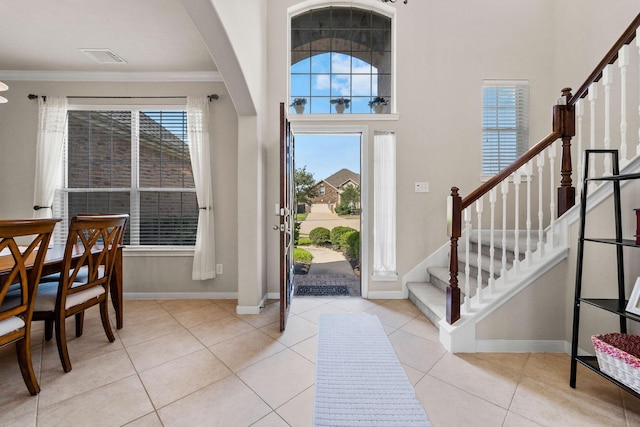 22610 Torrisdale Ln, Tomball, TX 77375 - entryway featuring stairway, healthy amount of natural light, tile patterned flooring, ornamental molding, and a high ceiling