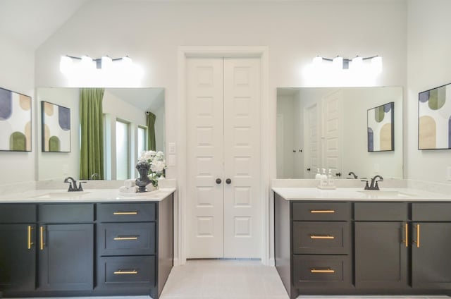 10711 Kingston Spring Dr, Missouri City, TX 77459 - bathroom featuring two vanities, vaulted ceiling, and a closet