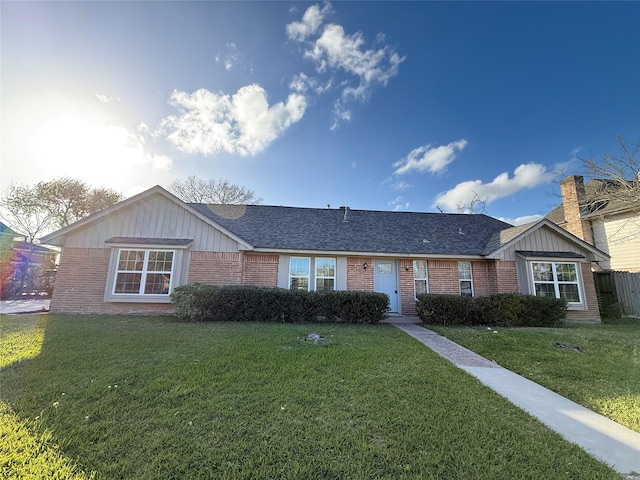 301 Old Bayou Dr, Dickinson, TX 77539 - ranch-style home with brick siding, a front yard, a shingled roof, and board and batten siding