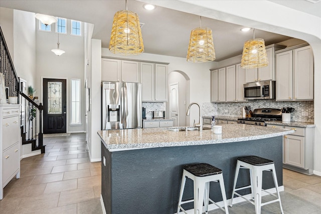 1861 Kenley Way, Alvin, TX 77511 - kitchen with stainless steel appliances, a sink, arched walkways, tasteful backsplash, and recessed lighting