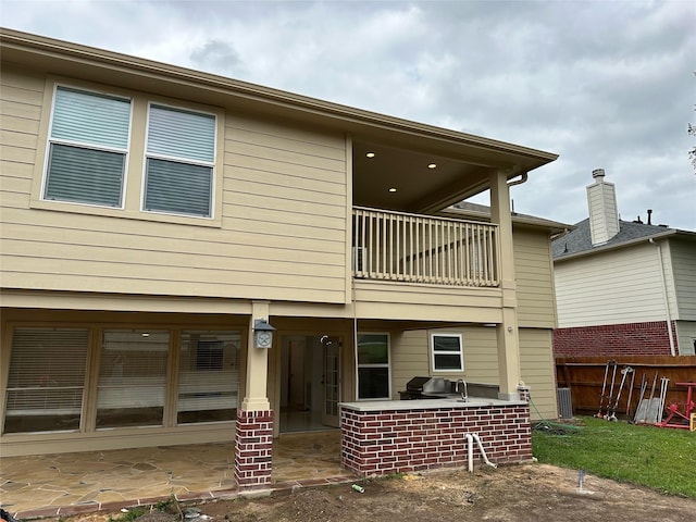 21207 Rushing Creek Ln, Katy, TX 77449 - rear view of property with a balcony, a patio, and an outdoor kitchen