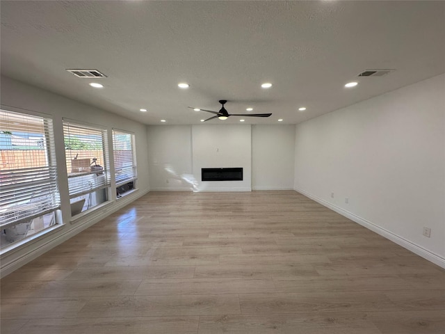 21207 Rushing Creek Ln, Katy, TX 77449 - unfurnished living room featuring light wood-type flooring, baseboards, recessed lighting, ceiling fan, and a fireplace