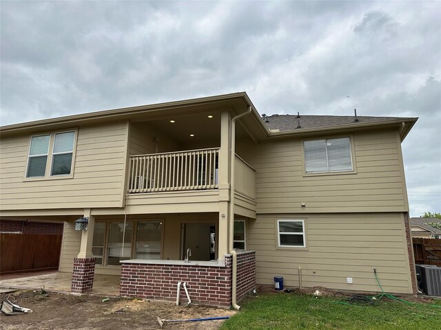 21207 Rushing Creek Ln, Katy, TX 77449 - back of house with a balcony, central AC unit, a patio, and a garage