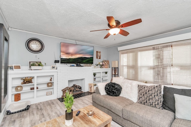 8209 Howard Dr, Houston, TX 77017 - living room featuring wood finished floors, a ceiling fan, a textured ceiling, a brick fireplace, and ornamental molding