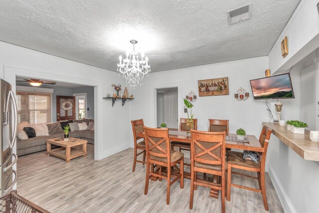8209 Howard Dr, Houston, TX 77017 - dining room featuring light wood-style flooring, a textured ceiling, baseboards, and a chandelier