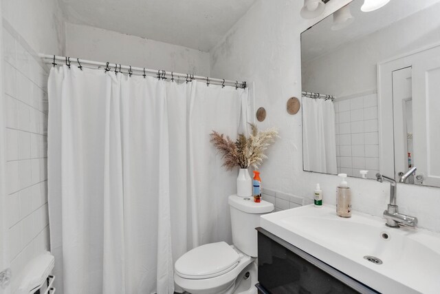 8209 Howard Dr, Houston, TX 77017 - full bath featuring toilet, vanity, tile walls, and a shower with curtain