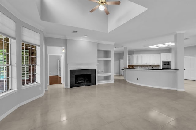 1930 Crisfield Dr, Sugar Land, TX 77479 - unfurnished living room featuring a ceiling fan, built in features, a tile fireplace, ornamental molding, and baseboards