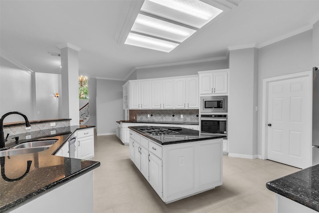 1930 Crisfield Dr, Sugar Land, TX 77479 - kitchen with stainless steel appliances, a sink, decorative backsplash, a kitchen island, and white cabinetry