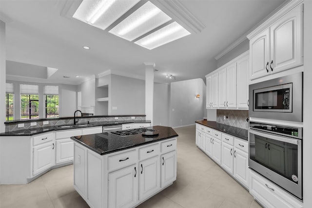 1930 Crisfield Dr, Sugar Land, TX 77479 - kitchen featuring stainless steel appliances, a sink, a peninsula, a kitchen island, and tasteful backsplash