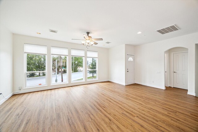 2402 Calumet St Unit C, Houston, TX 77004 - unfurnished living room featuring ceiling fan, arched walkways, light wood-type flooring, and baseboards