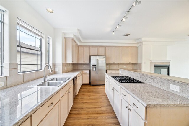 2402 Calumet St Unit C, Houston, TX 77004 - kitchen with stainless steel appliances, light brown cabinetry, a sink, and backsplash