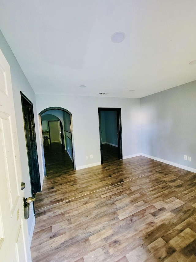 6115 Jade Ave, Port Arthur, TX 77640 - unfurnished room featuring wood finished floors, arched walkways, and baseboards