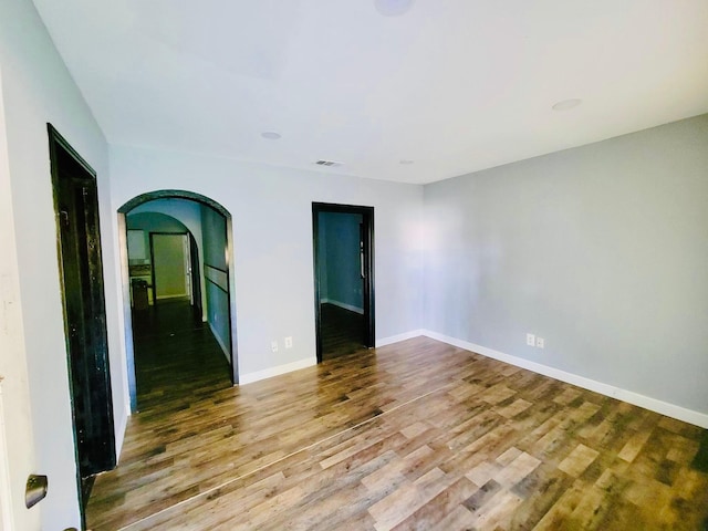 6115 Jade Ave, Port Arthur, TX 77640 - empty room with arched walkways, wood finished floors, and baseboards