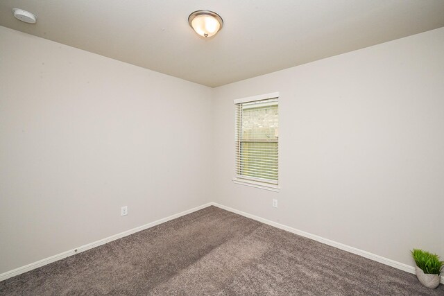 10130 Barn Owl Trl, Magnolia, TX 77354 - empty room featuring dark carpet, baseboards, and a smoke detector