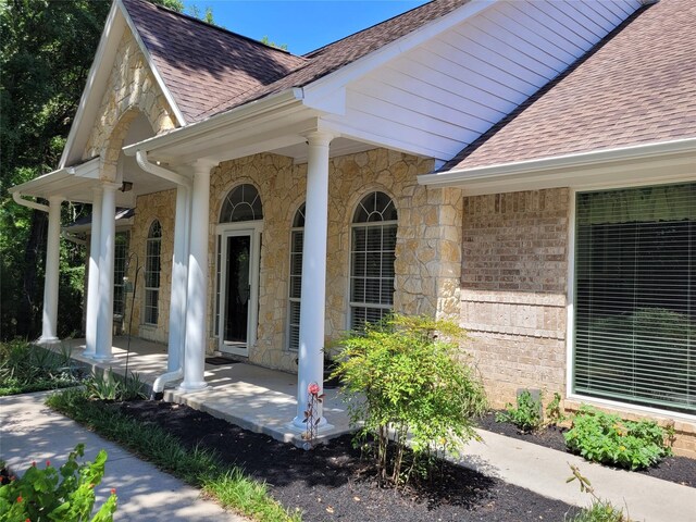 2626 Blue Lake Dr, Magnolia, TX 77354 - entrance to property with a shingled roof and stone siding