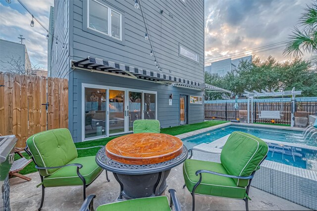 536 Rutland Pl, Houston, TX 77007 - pool at dusk featuring a fenced backyard and a pool with connected hot tub