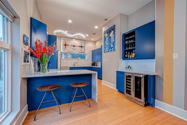 536 Rutland Pl, Houston, TX 77007 - indoor wet bar featuring wine cooler, decorative backsplash, light wood finished floors, recessed lighting, and baseboards