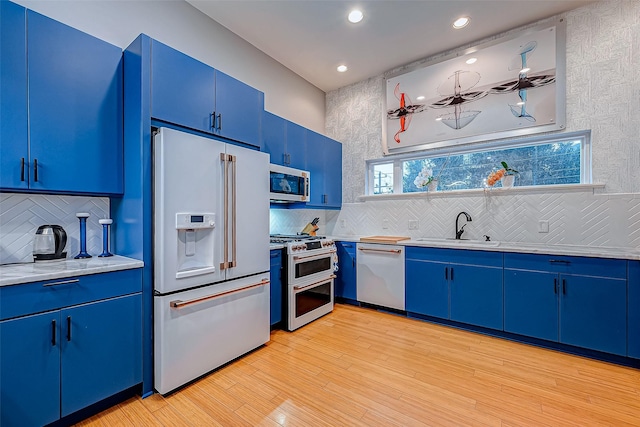 536 Rutland Pl, Houston, TX 77007 - kitchen with high quality appliances, blue cabinets, a sink, light countertops, and decorative backsplash