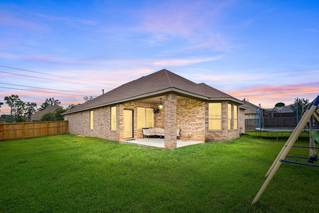 12510 Sherborne Castle Ct, Tomball, TX 77375 - rear view of property featuring a trampoline, a patio area, brick siding, and roof with shingles