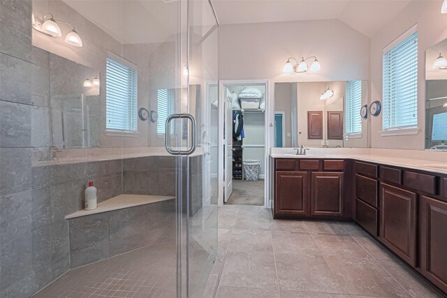 18526 Waterfall Creek Way, Cypress, TX 77429 - bathroom with a shower stall, double vanity, vaulted ceiling, a spacious closet, and healthy amount of natural light