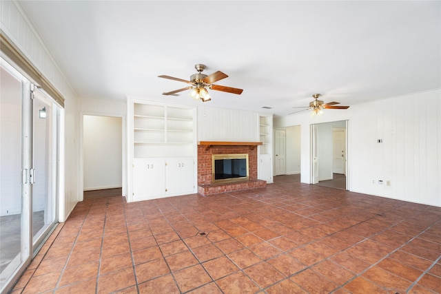 1908 Oak Shadows St, Baytown, TX 77520 - unfurnished living room with built in features, ceiling fan, a fireplace, and wood walls