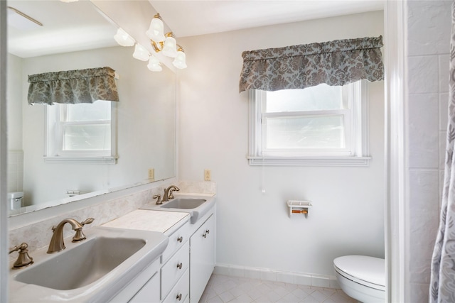 1908 Oak Shadows St, Baytown, TX 77520 - full bath with healthy amount of natural light, double vanity, toilet, and tile patterned floors