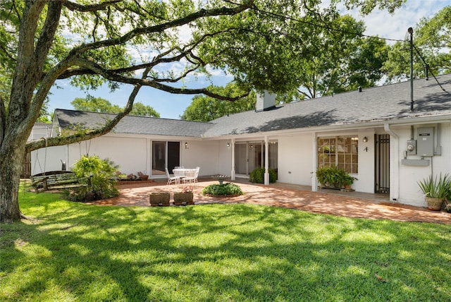 1908 Oak Shadows St, Baytown, TX 77520 - back of property with a lawn, a patio area, a chimney, and a shingled roof
