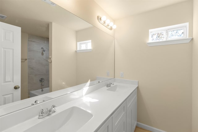 7754 Ave J, Houston, TX 77012 - bathroom featuring double vanity, baseboards, and bathtub / shower combination