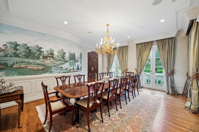 10911 Kemwood Dr, Houston, TX 77024 - dining room featuring a chandelier, ornamental molding, wainscoting, light wood-type flooring, and a decorative wall