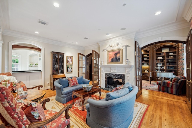 10911 Kemwood Dr, Houston, TX 77024 - living room with a fireplace, light wood-type flooring, arched walkways, recessed lighting, and ornamental molding