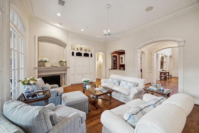 10911 Kemwood Dr, Houston, TX 77024 - living room with arched walkways, ornamental molding, ceiling fan, ornate columns, and wood finished floors
