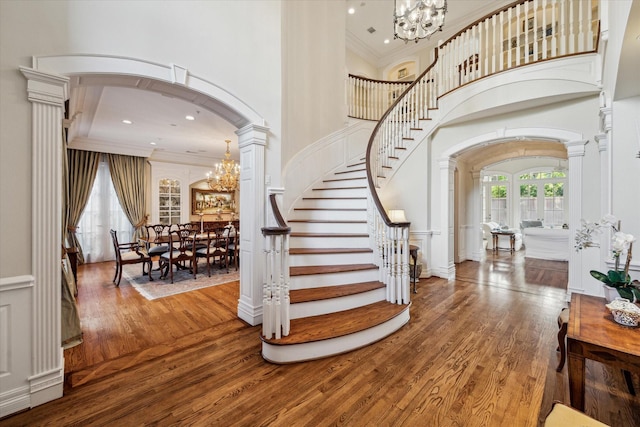 10911 Kemwood Dr, Houston, TX 77024 - foyer with a chandelier, arched walkways, crown molding, wood finished floors, and a towering ceiling