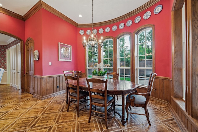 10911 Kemwood Dr, Houston, TX 77024 - dining room featuring a wainscoted wall, crown molding, a chandelier, arched walkways, and wooden walls