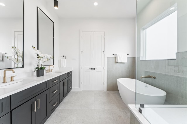 819 Dorothy St Unit B, Houston, TX 77008 - bathroom featuring a freestanding tub, double vanity, recessed lighting, a wainscoted wall, and tile walls