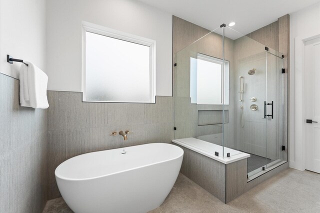 819 Dorothy St Unit B, Houston, TX 77008 - bathroom with a shower stall, a freestanding bath, tile walls, and a wainscoted wall