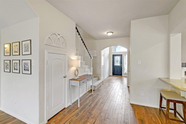 13823 Pointed Edge Ln, Cypress, TX 77429 - foyer entrance featuring arched walkways, hardwood / wood-style floors, stairs, and baseboards